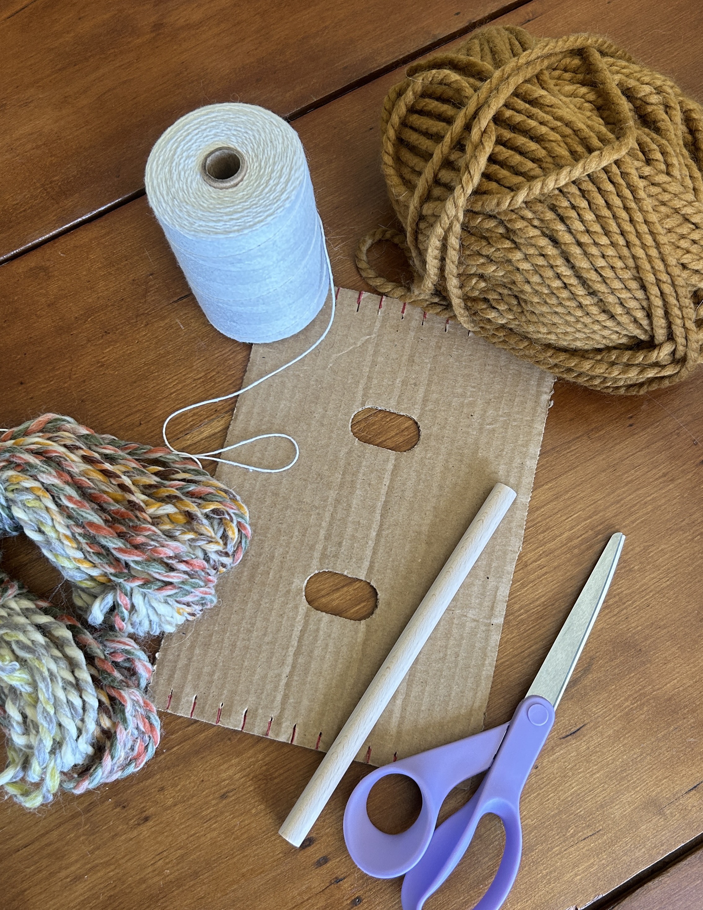 Weaving supplies — cardboard loom, yarn, and scissors